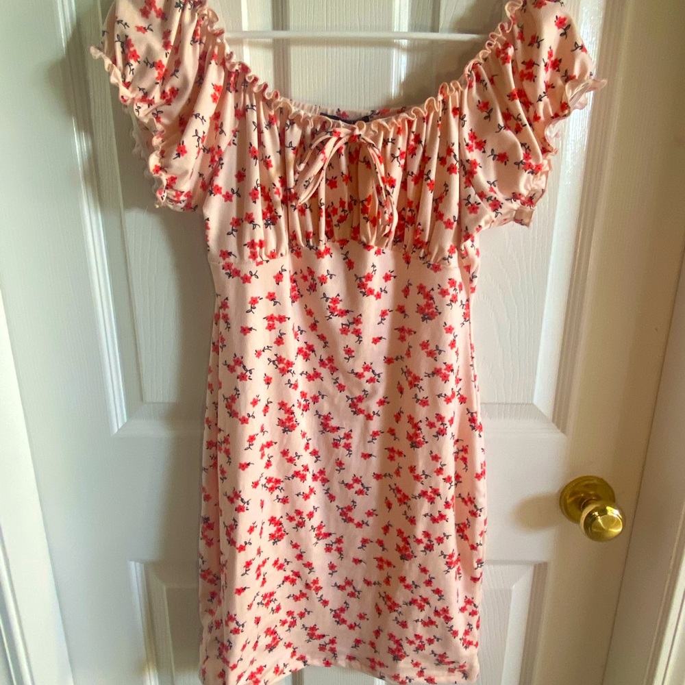 Pink mini dress with flowers all over. Size medium with a bow in the front.